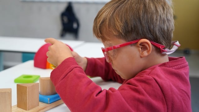 niño del colegio estudio3 juega con puzzles de madera