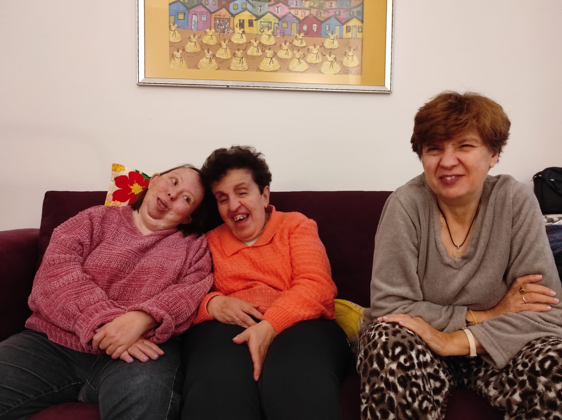 3 mujeres en un sofá riéndose